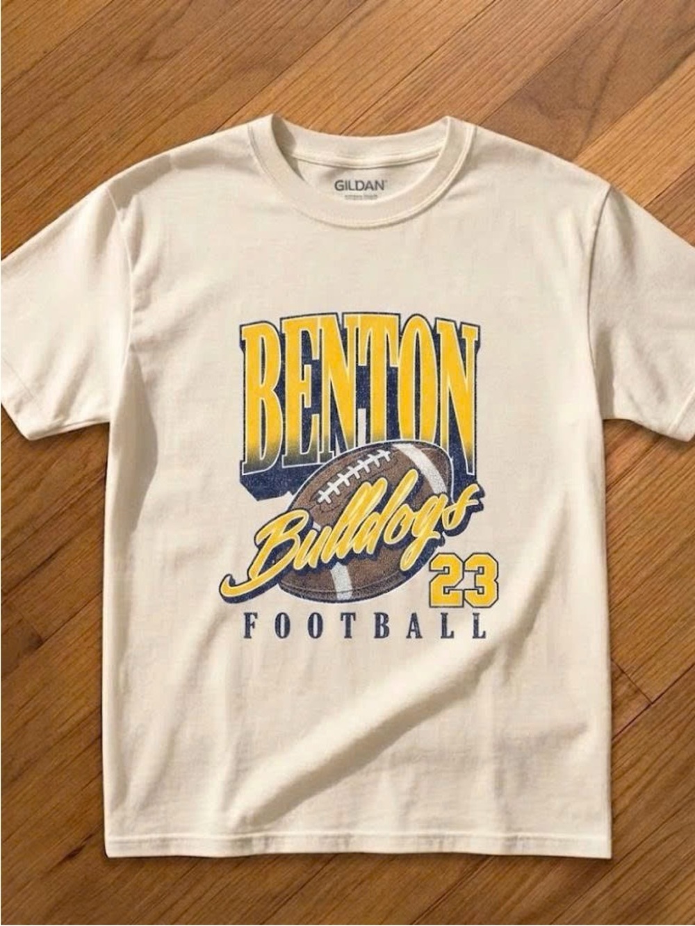 Cream Benton Bulldogs Football Graphic Tee with Yellow & Navy Print